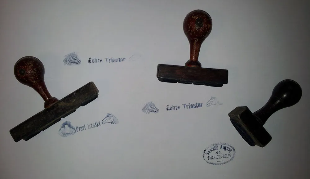 Three wooden rubber stamps with their prints: Echte Triester, Pravi tržaški, and Semolič August, Šmarjeta – Celje